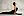 Eine Frau in einem schwarzen Sportoutfit macht Yoga. Sie ist auf der Yogamatte in der Haltung der Kobra.