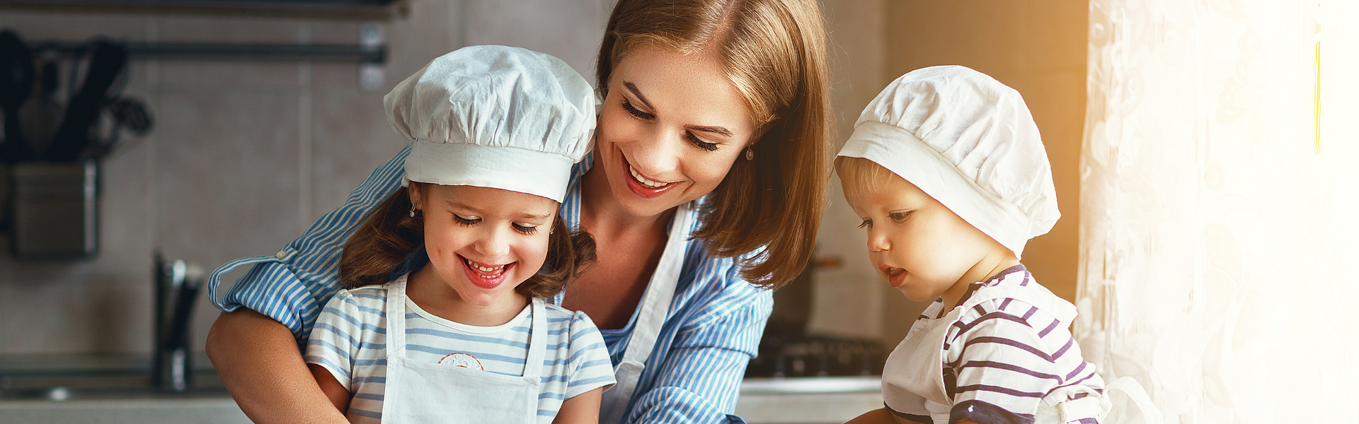 Mutter mit zwei Kindern bereitet ein gesundes Mittagessen vor. Leider gibt es auch Kinder die zu dick sind. Für diese gibt es das Angebot beim RICHTIG ESSEN – Gewichts-Coaching KOMBIPLUS.