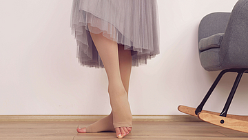 Frau trägt Kompressionsstrümpfe diese zählen zu den Heilmittel.