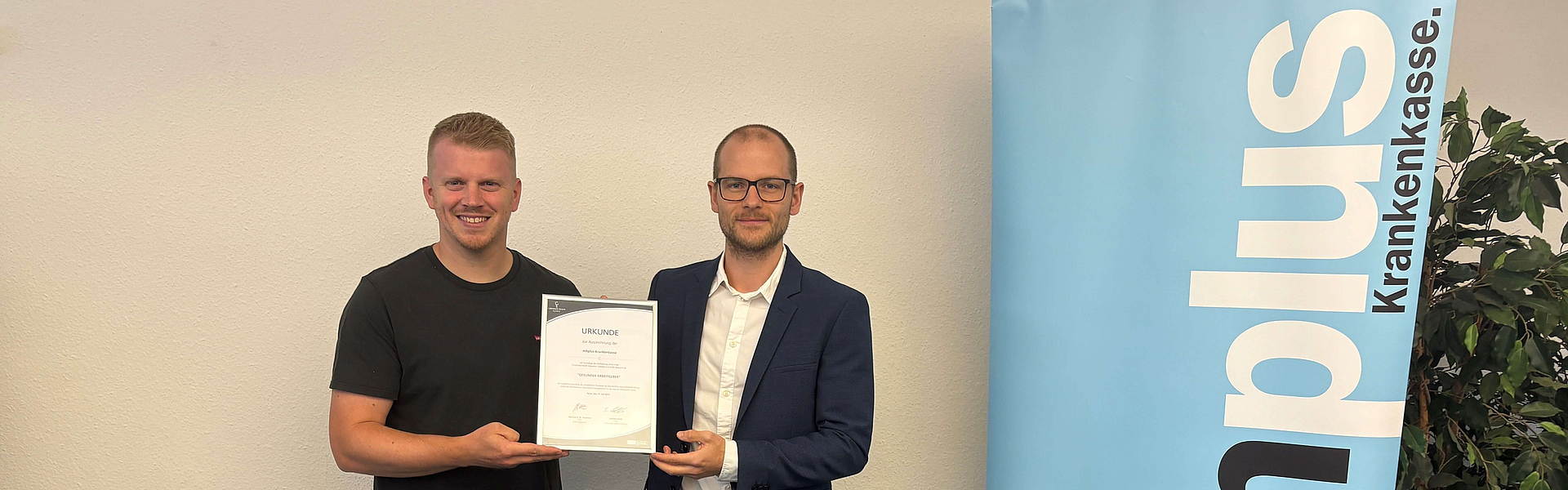 Jannik Tillmann von der mhplus (links) und Joshua Baaken von EUPD bei der Übergabe der Urkunde "Gesunder Arbeitgeber"