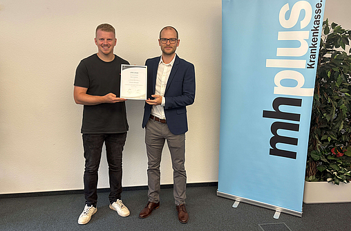 Jannik Tillmann von der mhplus (links) und Joshua Baaken von EUPD bei der Übergabe der Urkunde "Gesunder Arbeitgeber"