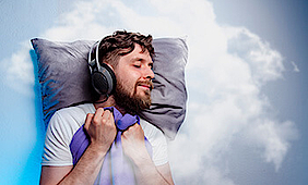 Mann mit Kopfhörern, schläft in den Wolken.