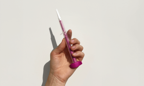 Hand mit einer Spritze diese wird für den HPV-Selbsttest verwendet.