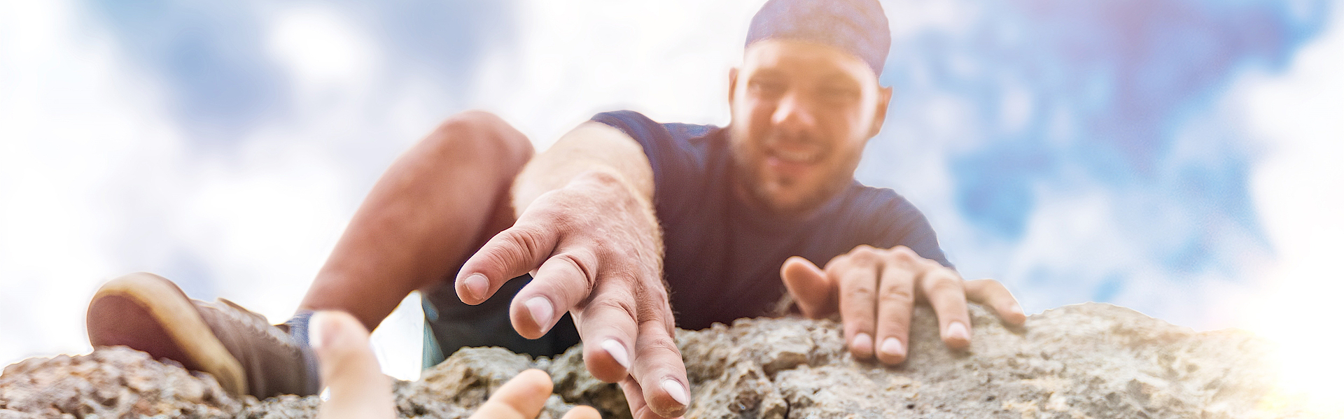 Bergsteiger reicht einem anderen die Hand