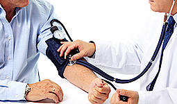 Nahaufnahme vom Blutdruckmessen. Ein Arzt misst bei einem Herrn den Blutdruck.