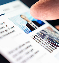 Hand scrollt durch News auf Smartphone