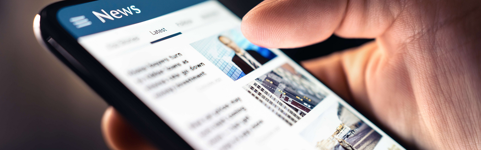 Hand scrollt durch News auf Smartphone