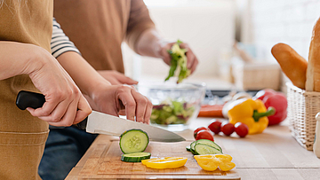 Menschen schneiden Gemüse für vegetarische Ernährung