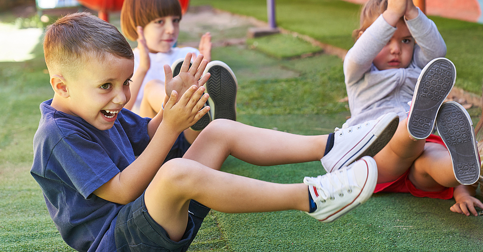 Kinder haben Spaß bei der Kindergymnastik im Freien.