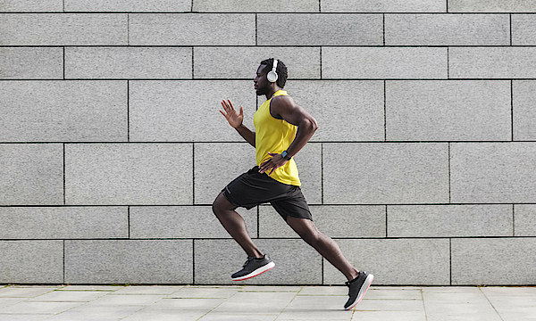 Mann geht Joggen mit Kopfhörern.