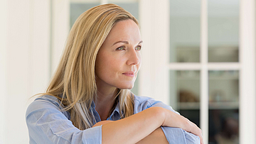 Die Frau ist krank und informiert sich über das Krankengeld für Arbeitslose.