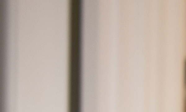 Ein junger Mann betrachtet Pokale. Er hat einen in der Hand und lacht.