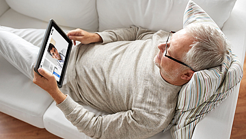Der Mann lässt sich über die TeleClinic online vom Arzt beraten. Die Telemedizin ist eine wichtige Stütze fürs Gesund werden.