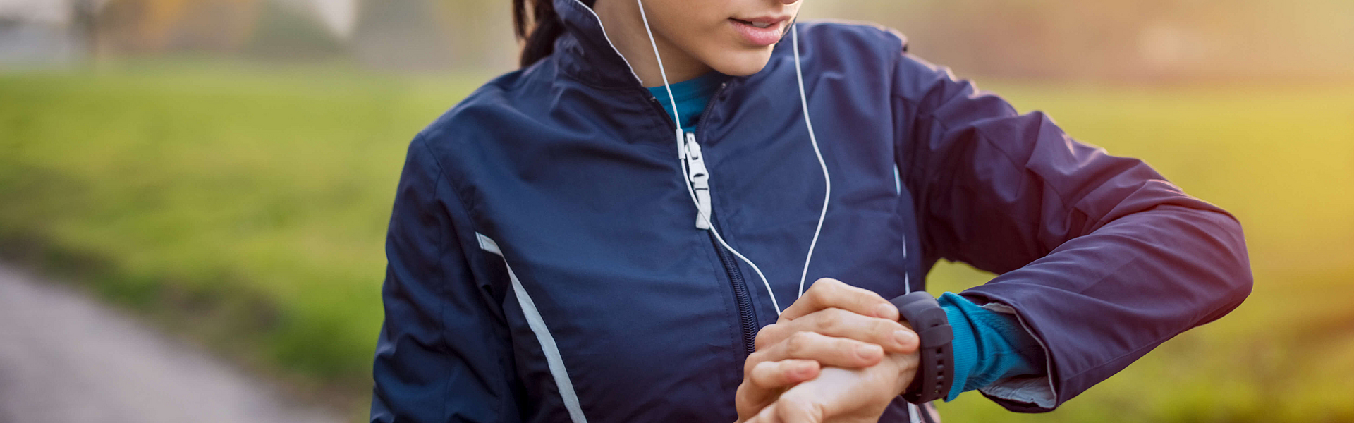 Eine Frau in Sportkleidung kontrolliert ihren Puls beim Sport