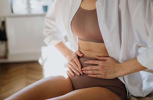 Symbolbild für Endometriose - Frau hält sich vor Schmerzen den Bauch