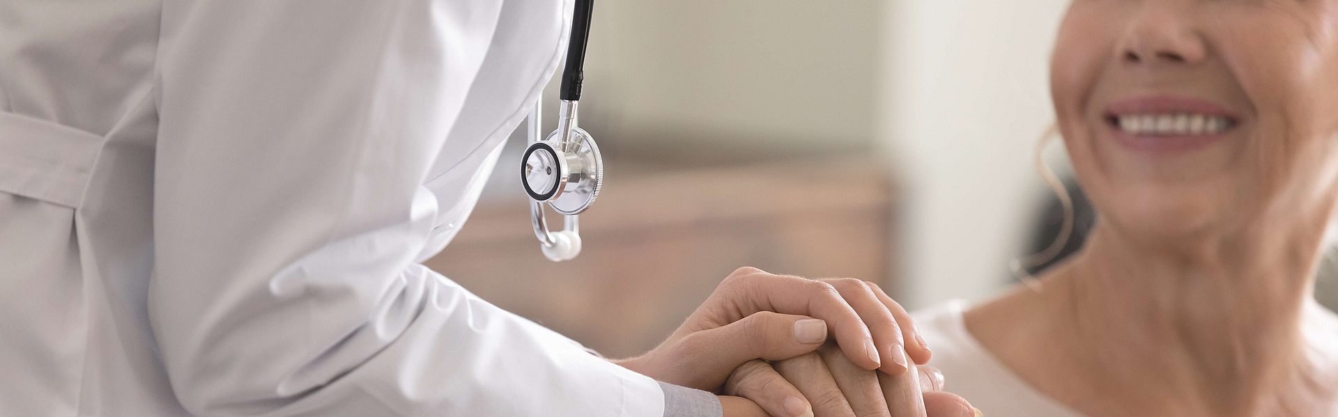 Ärztin unterhält sich bei einer älteren weiblichen Patientin.