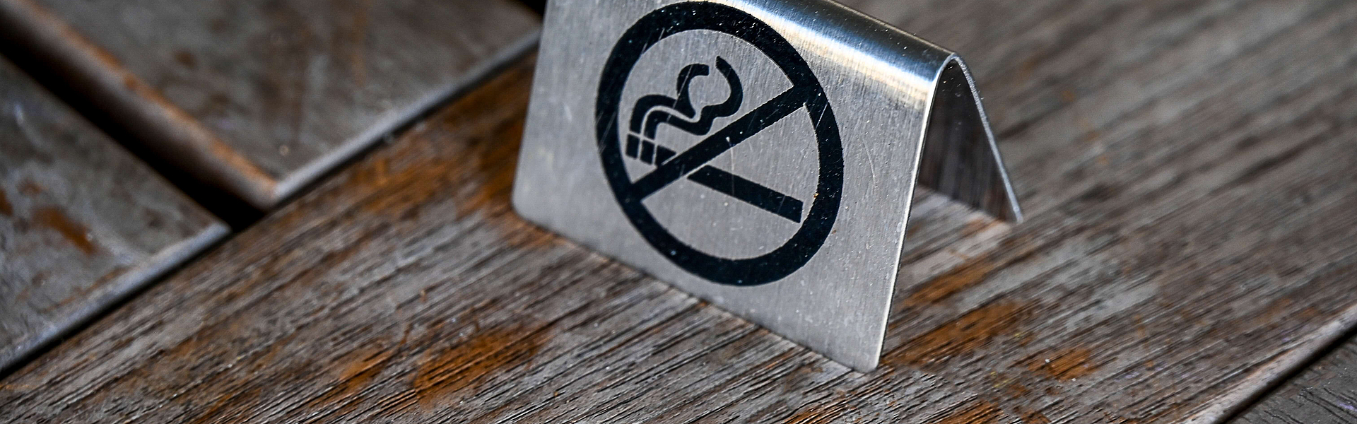 Auf einem Holztisch steht ein Nichtraucher-Schild