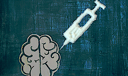 Darstellung eines Gehirns auf einer Tafel. Neben dem Gehirn befindet sich eine Spritze aus Zucker. Zusammen stellen sie das Konzept der Zucker-Abhängigkeit dar.