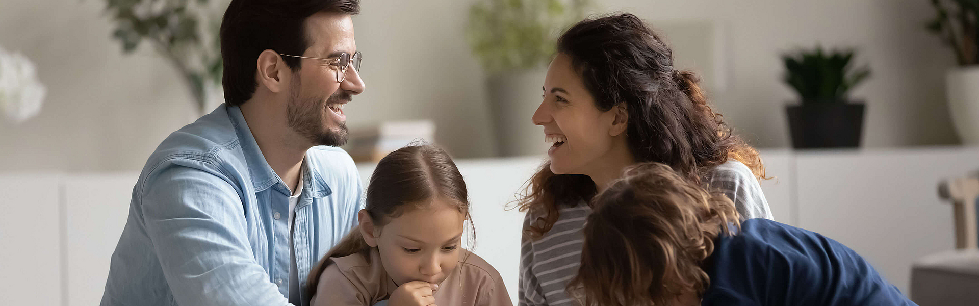 Eine Familie ist im Park und sitzt unter einem Baum.