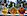 Drei Flaschen Ahornsirup mit unterschiedlicher Farbe, von hellgelb zu rotbraun, stehen auf einem Holz. Die Flaschen haben die Form eines Ahornblattes.