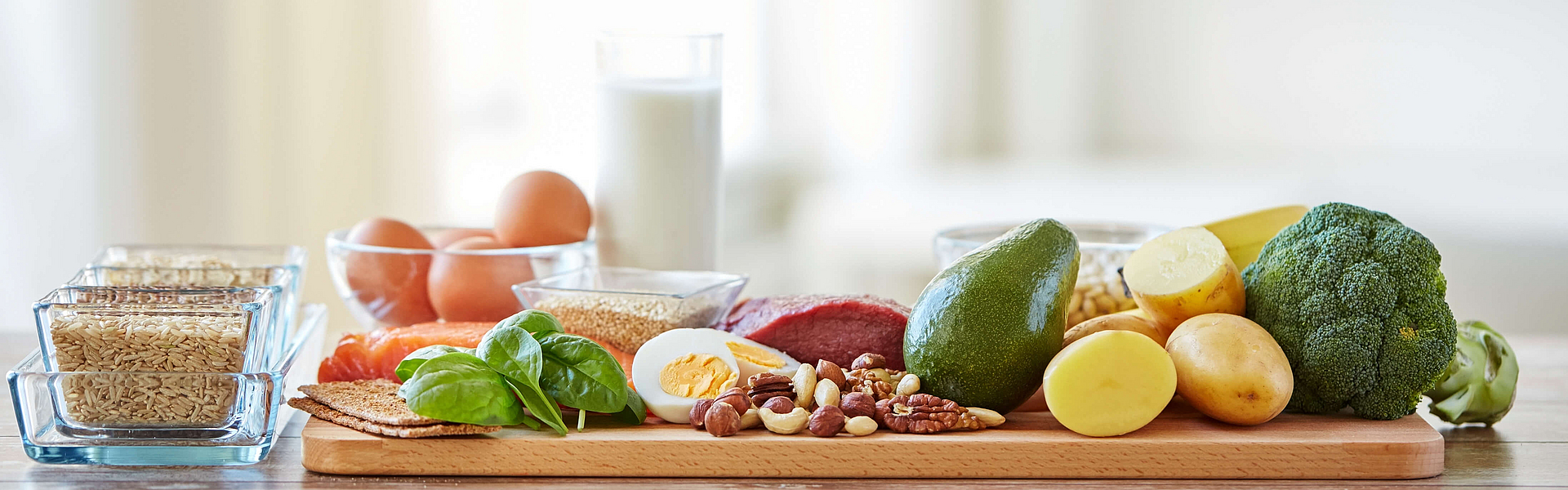 Auf einem Brettchen liegen Lebensmitteln mit Vitamin B wie zum Beispiel Obst, Gemüse und Milchprodukte