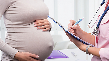 Schwangere hat schon einen schönen Baby-Bauch und ist bei einer Untersuchung bei ihrer Frauenärztin.