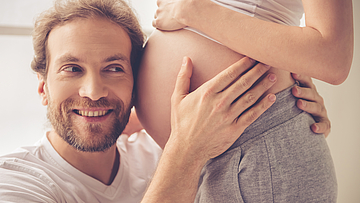Junges glückliches Paar. Die Frau ist schwanger und nimmt am Baby-Bonus teil.
