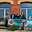 mhplus-Geschäftsstellenleiter Daniel Strötz steht vor der mhplus-Geschäftstelle in Hof zusammen mit einer Blutspenderin, der Bürgermeisterin und dem stellvertretenden Landrat vor einem Plakat zur Blutspendeaktion.