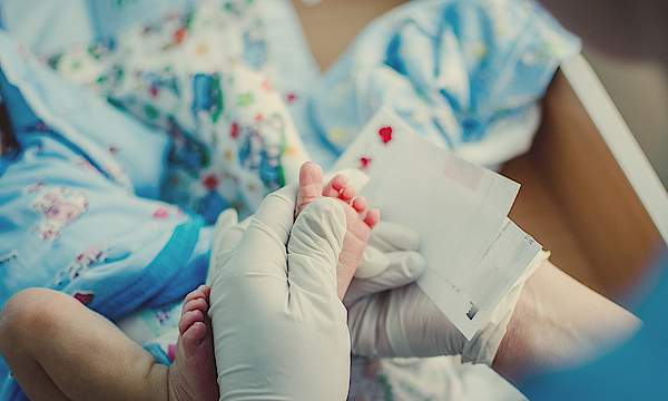 Bei einem Baby wird für eine Untersuchung Blut vom Fuß genommen.