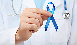 Doktor hält eine blaue Schleife als Zeichen gegen Darmkrebs.