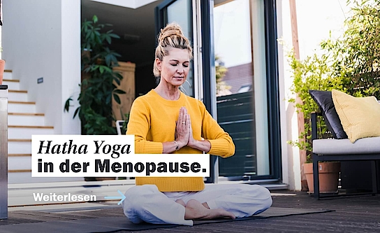 Frau in Yogapose auf Terasse
