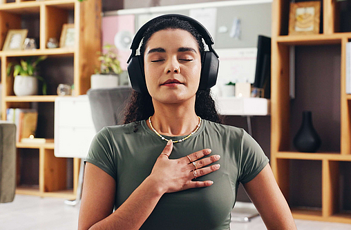 Frau macht im Wohnzimmer Atemübungen