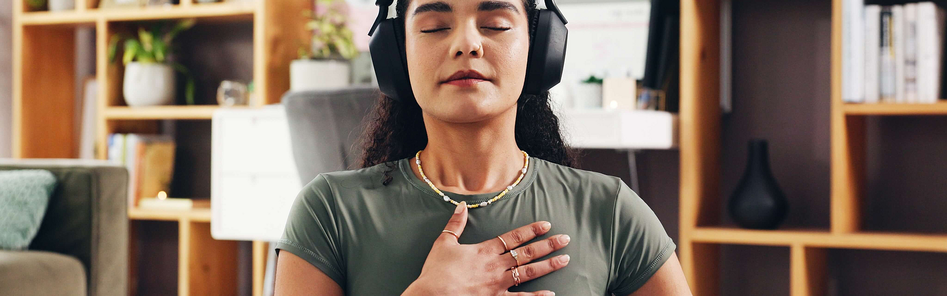 Frau macht im Wohnzimmer Atemübungen