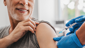 Ein Mann bekommt vom Arzt eine Impfung. 