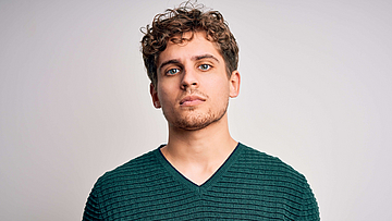 junger Mann vor einem grauen Hintergrund