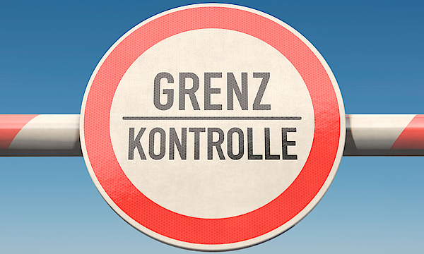 Schranke an einer Grenze mit der Aufschrift Grenze und Kontrolle