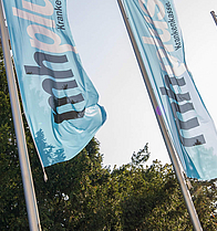 Das Bürogebäude und Hauptsitz der mhplus Krankenkasse in Ludwigsburg mit Flaggen und Bäumen davor