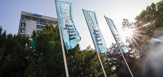 Das Bürogebäude und Hauptsitz der mhplus Krankenkasse in Ludwigsburg mit Flaggen und Bäumen davor