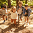 Eine Gruppe von Kindern läuft im Wald auf. Mehrere ethnische Kinder, die im Wald zusammen spielen.