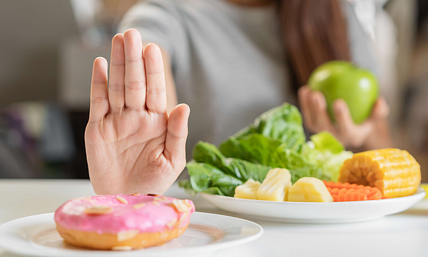  Frau lehnt Donut mit entzündungsförderndem Zucker ab