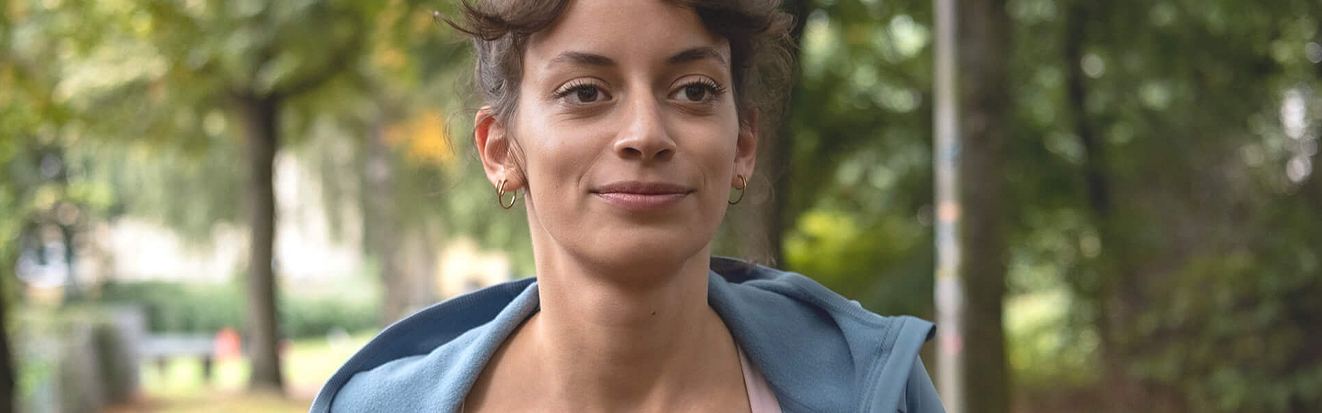 Eine Frau joggt durch den Wald. Sie nimmt über die Bonus-App an den Bonusprogrammen der mhplus teil.