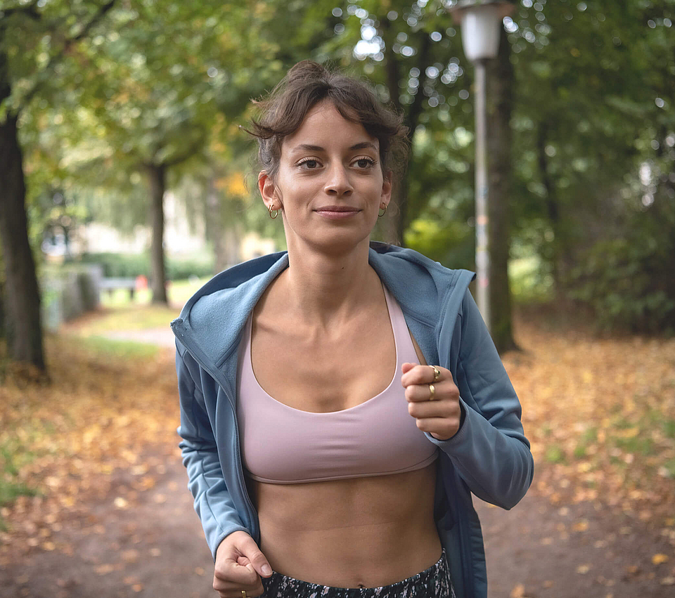 Junge Frau joggt im Wald.