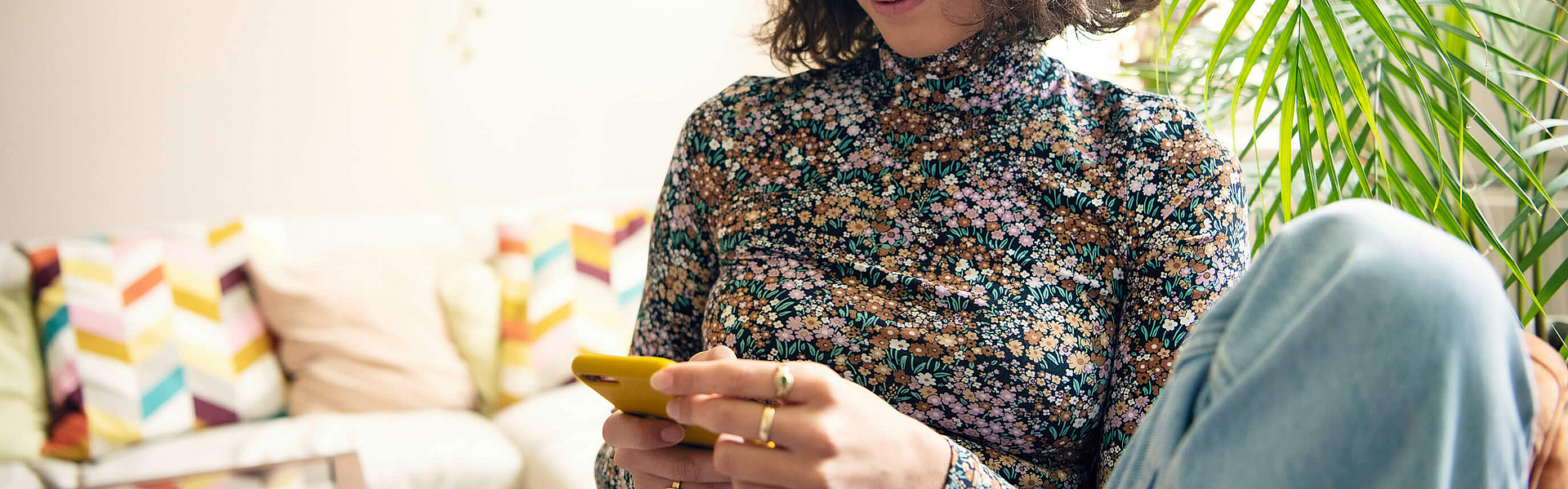 Junge Frau schaut auf ihr Smartphone.