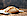 Ein Brot liegt auf einem Geschirrtuch auf einer Holzplatte. Der Hintergrund ist dunkel.