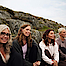 Frauen unterschiedlichen Alters die gemeinsam auf einem Felsen sitzen