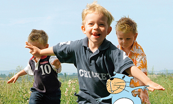 Kinder rennen auf einer Wiese und haben viel Spaß.