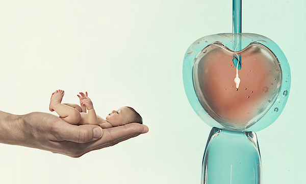 Auf einer vergrößerten Handfläche liegt ein Baby, ein Herz in einer Blase hängt an einem Band.