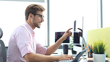 Ein Mann arbeitet im Büro an einem Laptop.