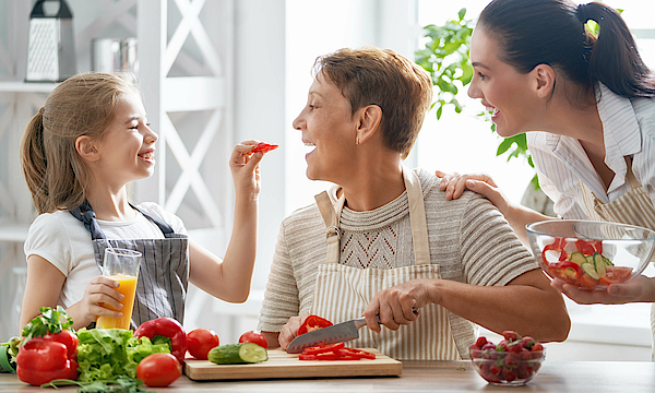 Zu sehen ist eine Familie die glücklich Zeit in der Küche verbringt