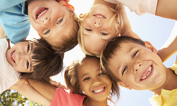 Kinder stehen im Kreis und schauen in die Kamera.